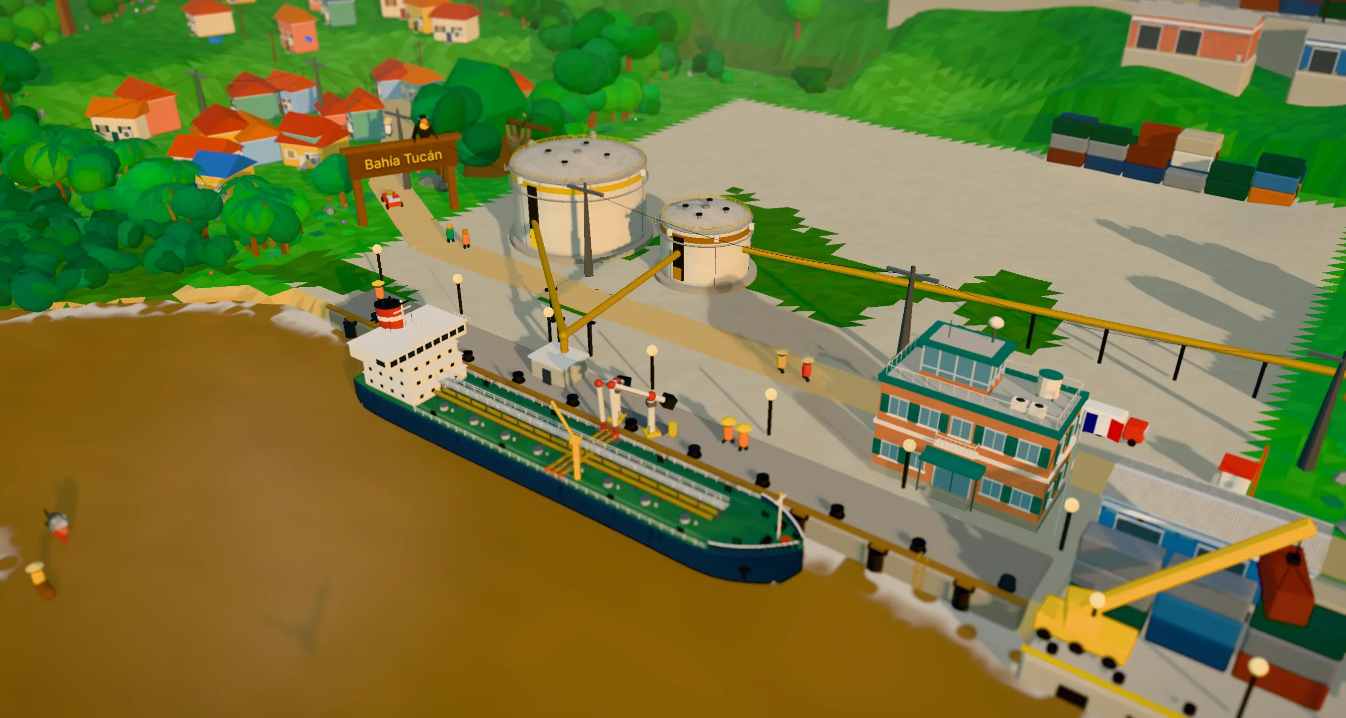 Bahía Tucán as a model on a table: a tanker alongside the fuel quay with the loading arms on her, two fuel tanks behind, the town on the hill and the cargo wharf with its crane.